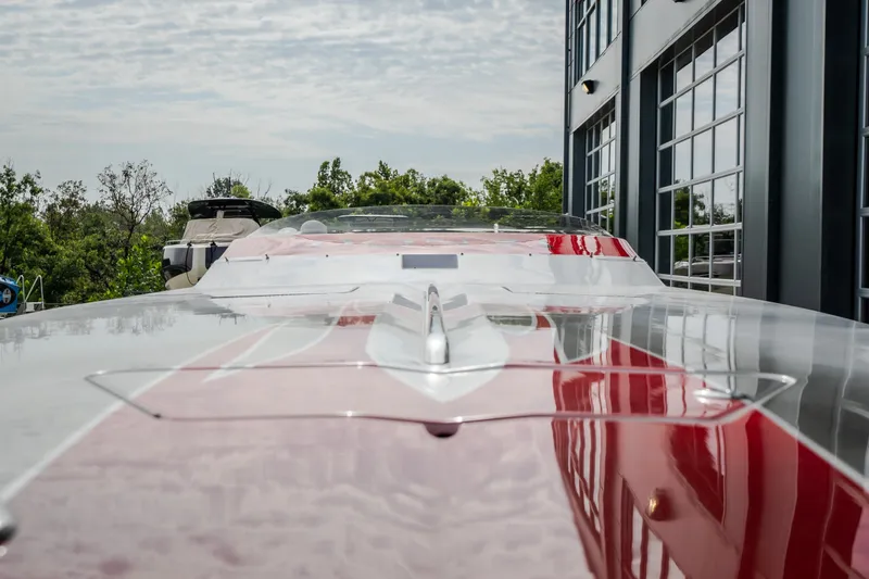 Slide: The Image of 2005 Donzi 35 ZR boat with sleek red and white design, parked near a modern building. - 45