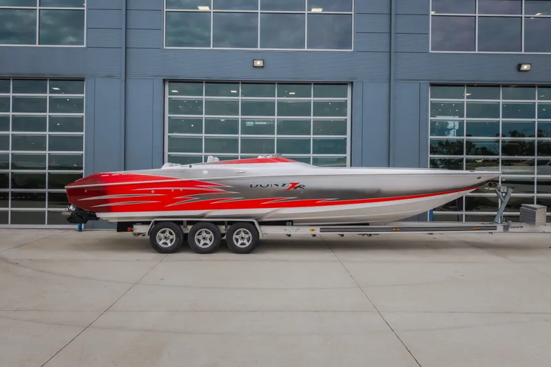 Slide: The Image of 2005 Donzi 35 ZR speedboat with red and silver design on a trailer. - 51
