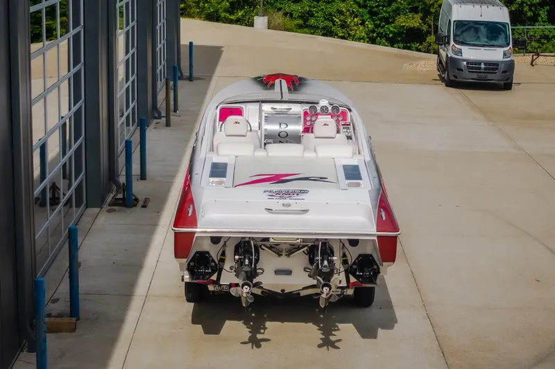 Slide: The Image of 2005 Donzi 35 ZR speedboat parked outside a garage, showcasing sleek design and powerful engines. - 13