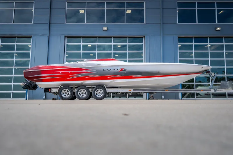 The Image of 2005 Donzi 35 ZR speedboat with red and silver design on a trailer. - 3