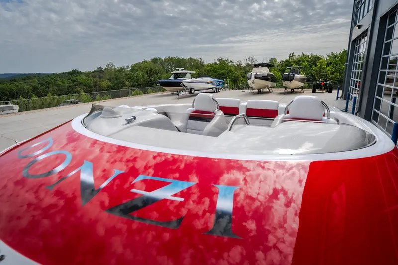 Slide: The Image of 2005 Donzi 35 ZR speedboat with red detailing, parked outdoors near other boats. - 9