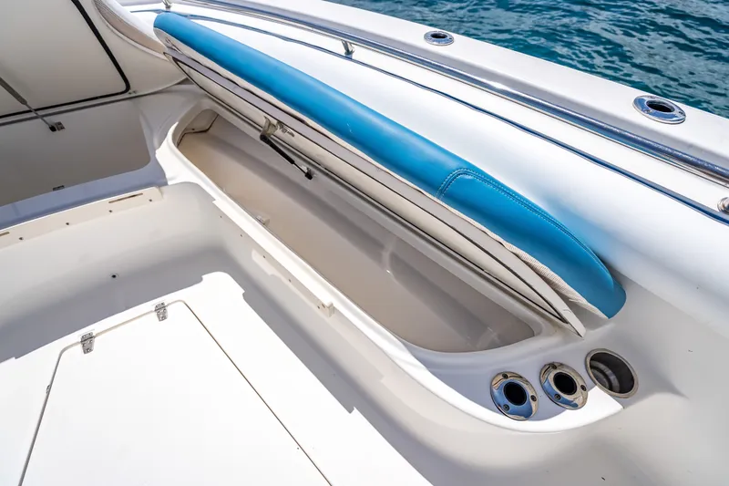 Slide: The Image of 2006 Boston Whaler 320 Outrage boat storage compartment with blue cushioned seating. - 32