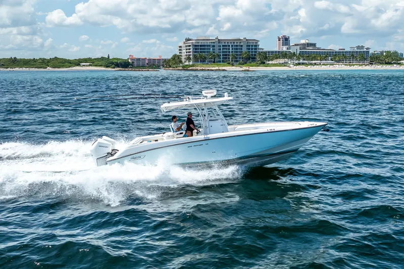 Slide: The Image of 2006 Boston Whaler 320 Outrage cruising on ocean near coastal buildings. - 17