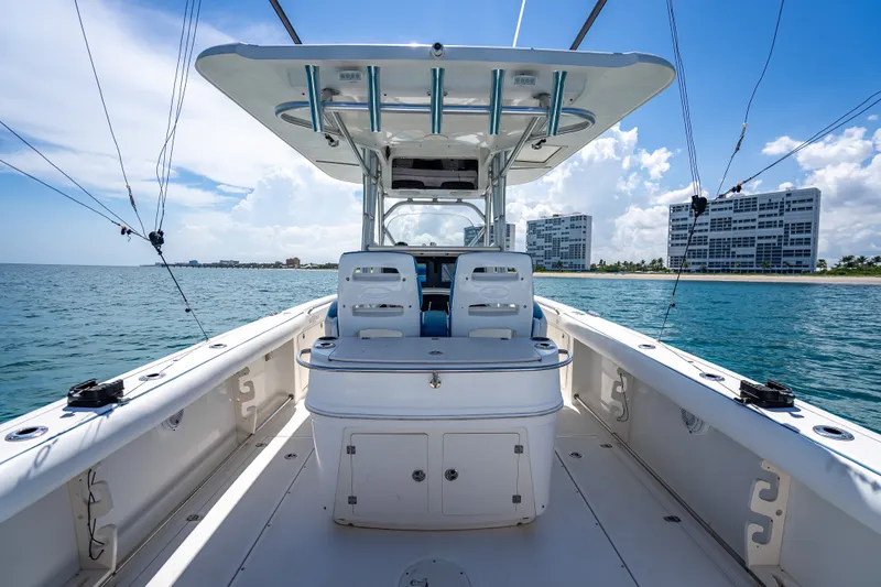 Slide: The Image of 2006 Boston Whaler 320 Outrage boat on water, clear sky, coastal buildings in background. - 53