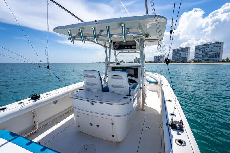 Slide: The Image of 2006 Boston Whaler 320 Outrage boat on calm ocean near modern buildings. - 52
