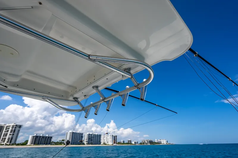 Slide: The Image of 2006 Boston Whaler 320 Outrage boat with rod holders, ocean view, and city skyline. - 42