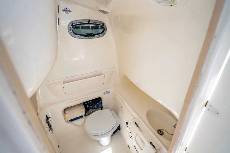 Slide: The Image of Interior of 2006 Boston Whaler 320 Outrage boat bathroom with toilet and sink. - 23