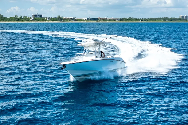 Slide: The Image of 2006 Boston Whaler 320 Outrage cruising on blue ocean near coastline. - 21