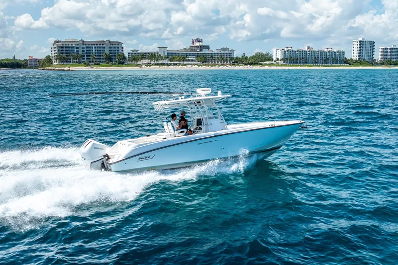 Slide: The Image of 2006 Boston Whaler 320 Outrage cruising on blue ocean near coastal buildings. - 18