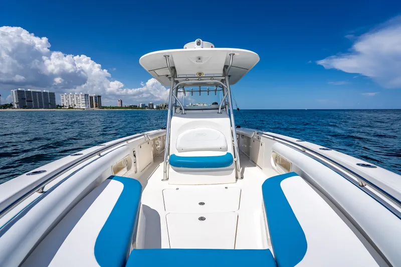 Slide: The Image of 2006 Boston Whaler 320 Outrage boat on open water, clear sky, coastal buildings. - 27