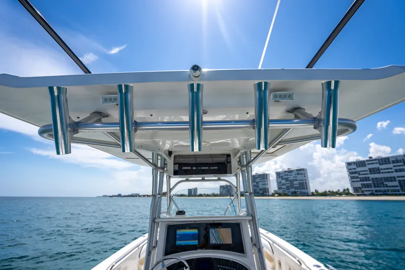 Slide: The Image of 2006 Boston Whaler 320 Outrage boat console with rod holders, ocean view, sunny day. - 51