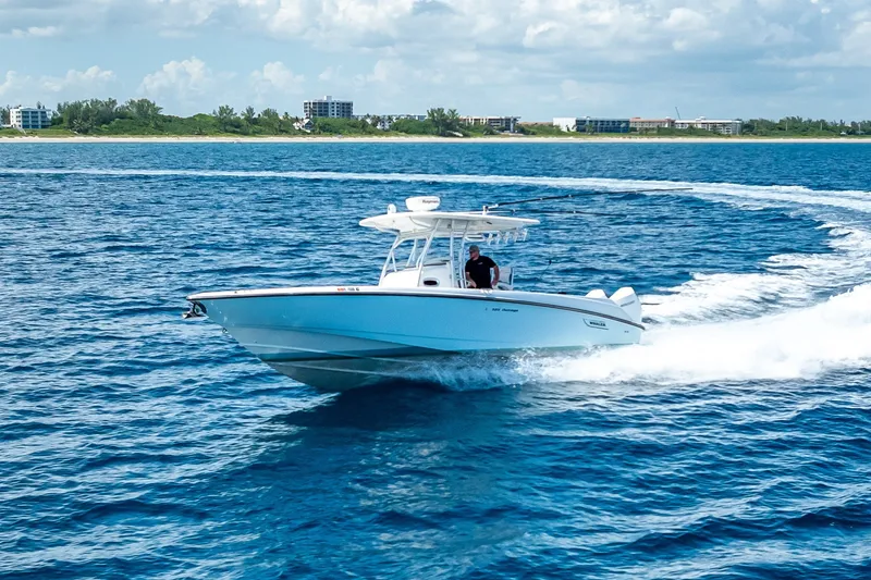 Slide: The Image of 2006 Boston Whaler 320 Outrage cruising on open blue water near coastline. - 22
