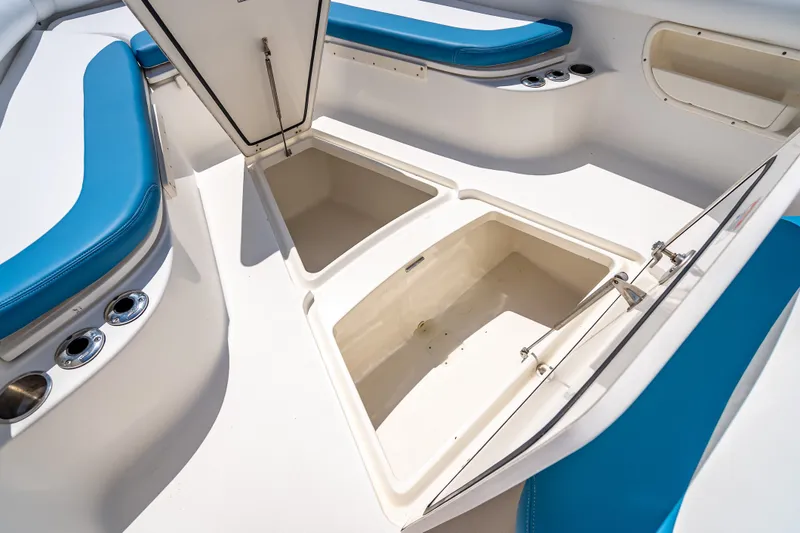Slide: The Image of 2006 Boston Whaler 320 Outrage boat interior with open storage compartments and blue seating. - 34