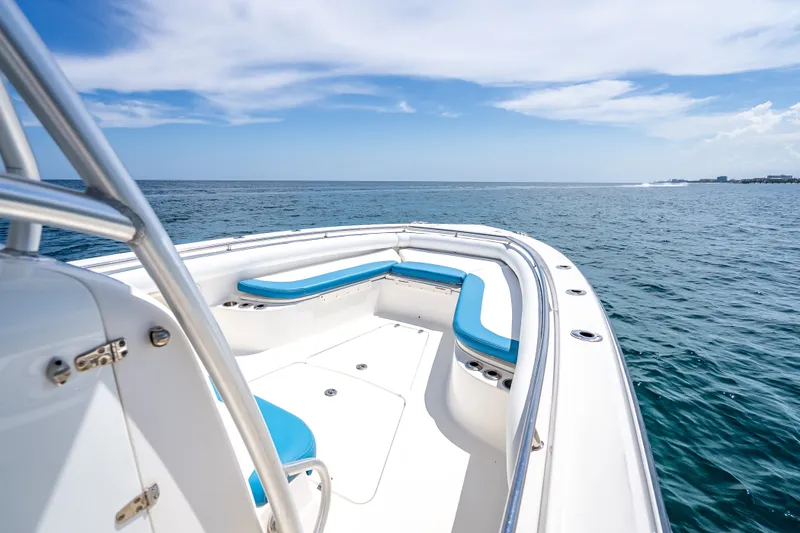 Slide: The Image of 2006 Boston Whaler 320 Outrage boat on open sea with blue seating and clear skies. - 26