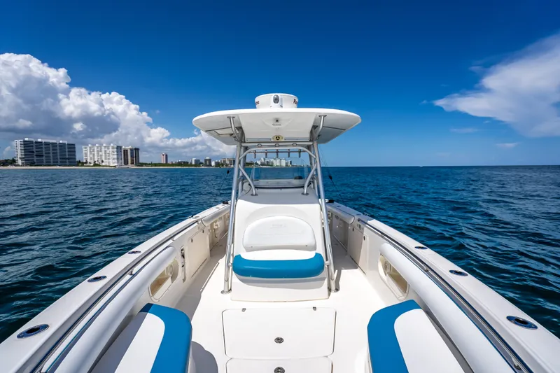 Slide: The Image of 2006 Boston Whaler 320 Outrage boat on open sea with city skyline. - 29