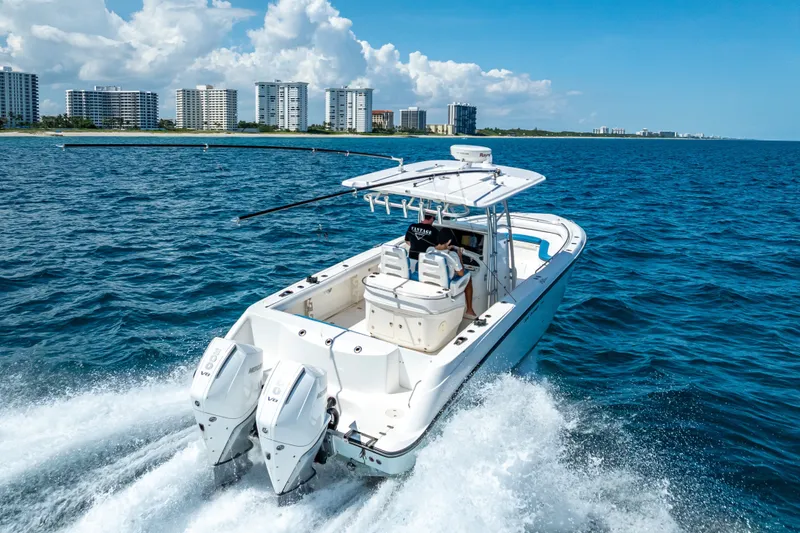 Slide: The Image of 2006 Boston Whaler 320 Outrage cruising on ocean near city skyline. - 19
