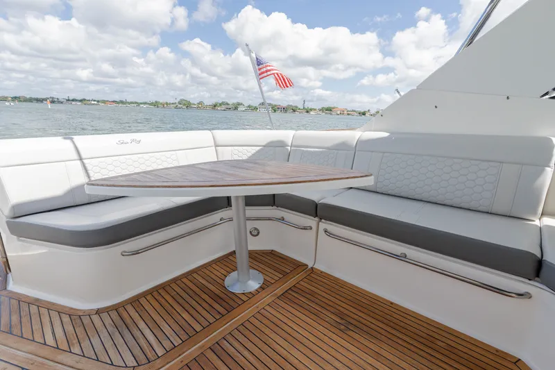 Slide: The Image of The 2024 Sea Ray Sundancer 320 Outboard features an elegant seating area with a wooden table and cushioned benches. - 20
