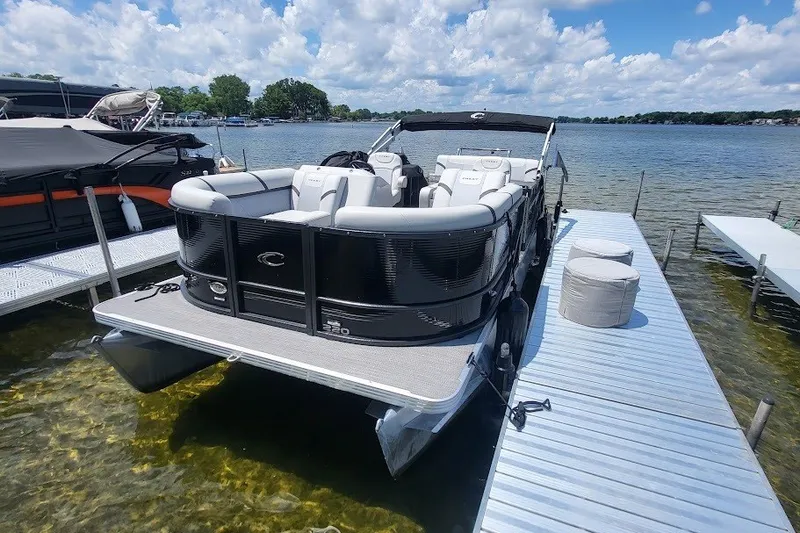 The Image of 2023 Crest 220 SLS Classic LX pontoon boat docked on a sunny lake. - 0