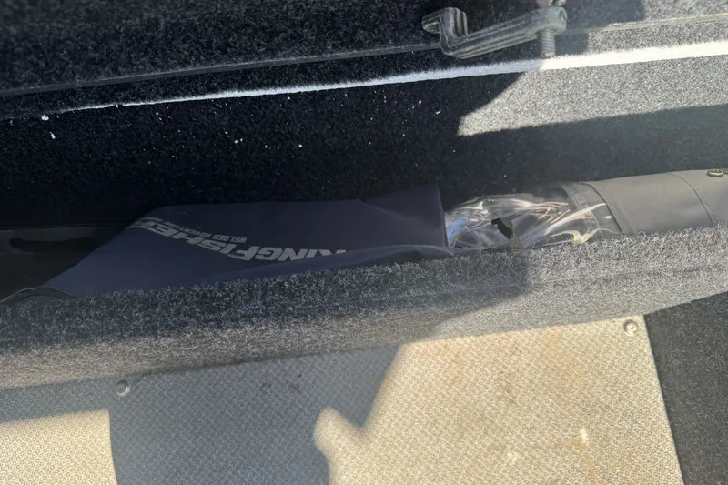 Slide: The Image of Storage compartment in 2023 KingFisher 1825 Warrior Sport boat, featuring carpeted interior. - 32