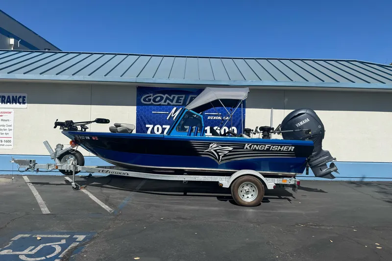The Image of 2023 KingFisher 1825 Warrior Sport boat on trailer, parked outside dealership. - 1