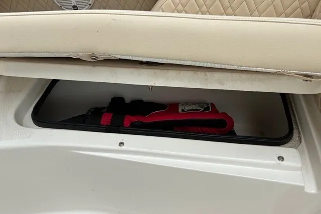 Slide: The Image of Storage compartment in a 2021 Century 24 Resorter boat with a red tool inside. - 53