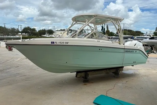 Slide: The Image of 2021 Century 24 Resorter boat on dry dock, light blue hull, overcast sky. - 22