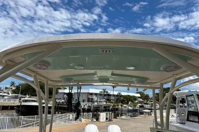 Slide: The Image of 2021 Century 24 Resorter boat canopy with speakers, docked under a blue sky. - 28