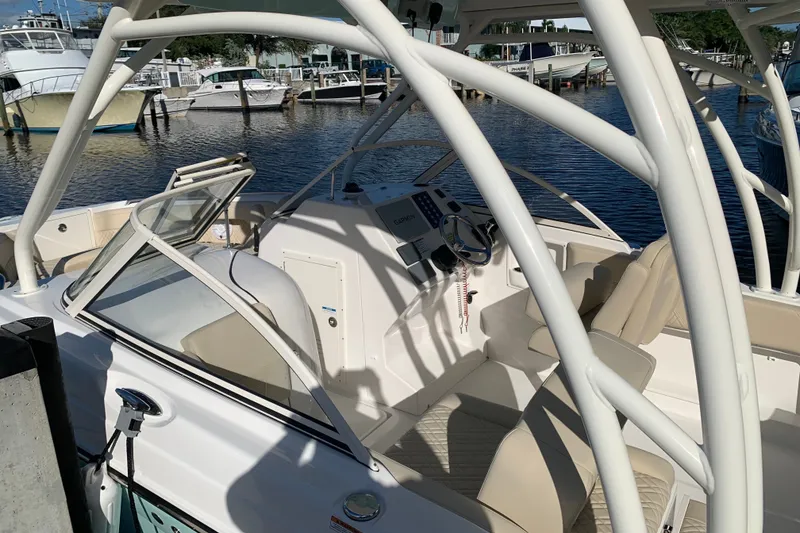 Slide: The Image of 2021 Century 24 Resorter boat interior with helm, seats, and marina view. - 16