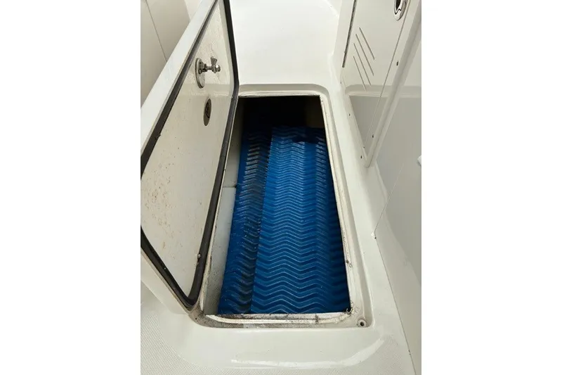 Slide: The Image of Open storage compartment on 2021 Century 24 Resorter boat with blue mat inside. - 54
