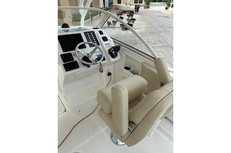 Slide: The Image of 2021 Century 24 Resorter boat interior with steering wheel and beige seating. - 33