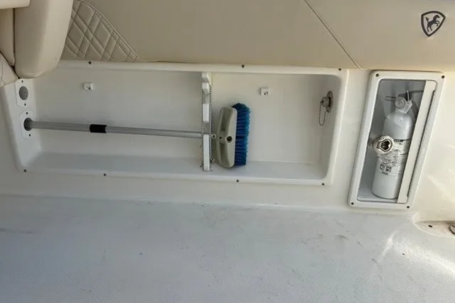 Slide: The Image of Storage compartment in 2021 Century 24 Resorter boat with cleaning tools and fire extinguisher. - 42