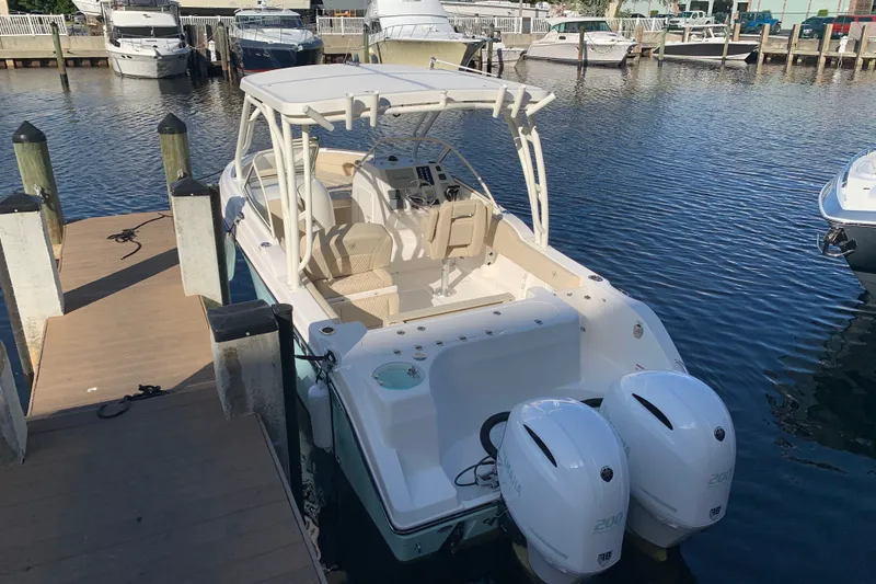 The Image of 2021 Century 24 Resorter boat docked with dual outboard engines in a marina. - 15