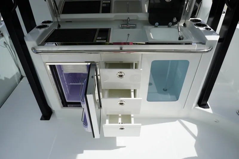 Slide: The Image of 2027 Jeanneau Leader 10.5 WA Series 2 boat kitchen with open drawers and fridge. - 15
