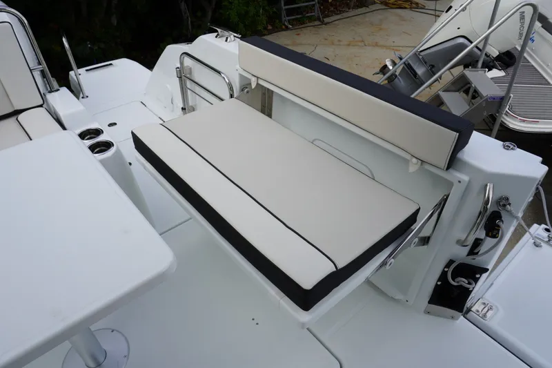 Slide: The Image of 2027 Jeanneau Leader 10.5 WA Series 2 boat seating area with white cushions and table. - 5