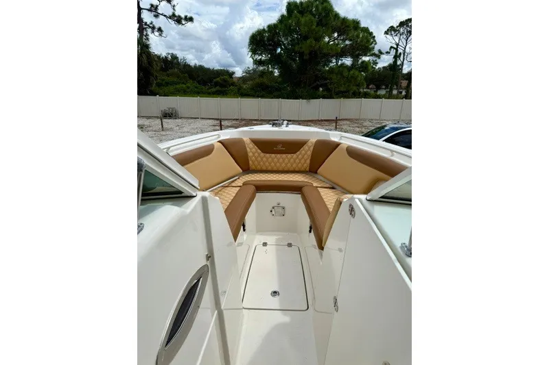 Slide: The Image of 2015 Sailfish 276 DC boat interior with tan seating and white deck. - 15