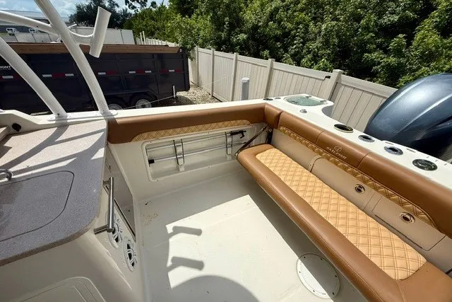 Slide: The Image of 2015 Sailfish 276 DC boat interior with tan seating and fishing rod holders. - 6
