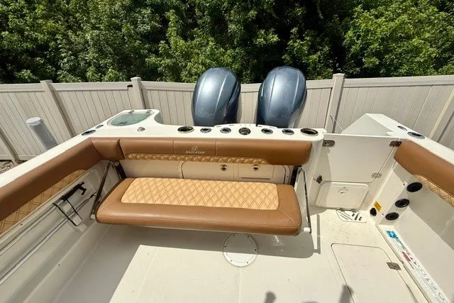 Slide: The Image of 2015 Sailfish 276 DC boat interior with tan seating and dual outboard motors. - 5