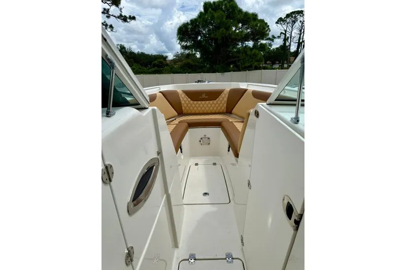 Slide: The Image of 2015 Sailfish 276 DC boat interior with tan seating and white deck. - 14