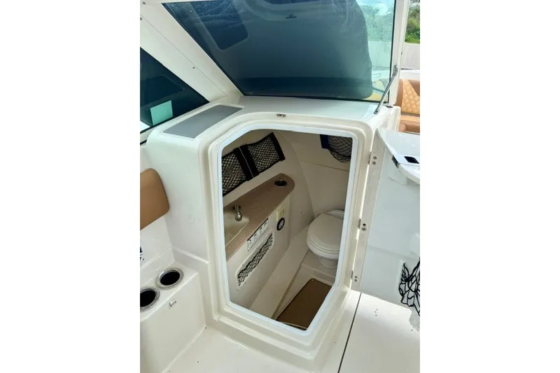 Slide: The Image of 2015 Sailfish 276 DC boat interior with compact bathroom and sink. - 16