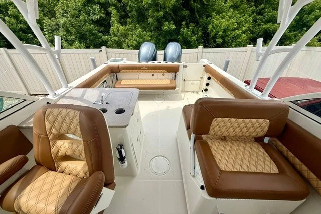 Slide: The Image of 2015 Sailfish 276 DC boat interior with brown leather seating and dual engines. - 9