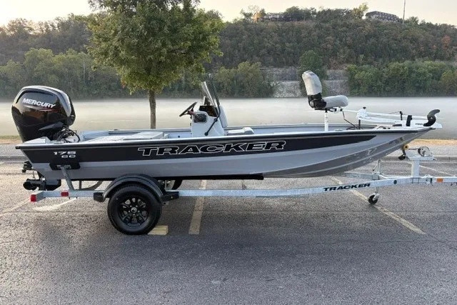 The Image of 2027 Tracker Bass Tracker 175 CC boat on trailer, parked near a scenic river. - 0