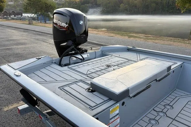 Slide: The Image of 2027 Tracker Bass Tracker 175 CC boat with Mercury engine, parked near a serene lake. - 23