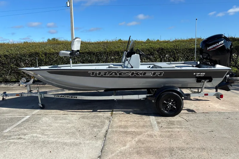 The Image of 2027 Tracker Bass Tracker 175 CC boat on trailer, parked outdoors under clear sky. - 0