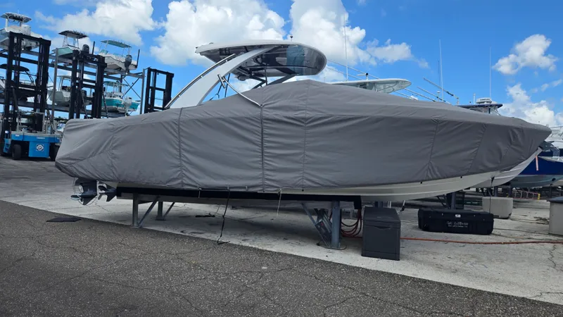 Slide: The Image of A 2023 Cobalt 30SC boat is on a stand, covered with a gray tarp. - 26