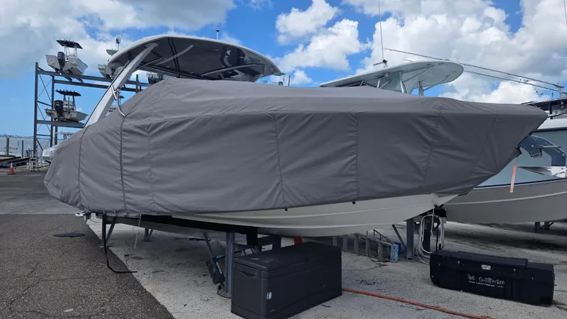 Slide: The Image of A 2023 Cobalt 30SC boat is covered with a gray tarp, resting on a dock. - 27