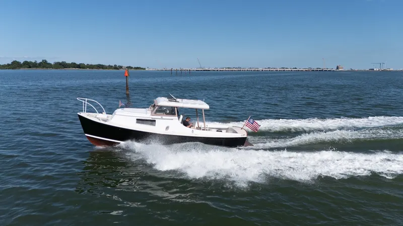 Slide: The Image of A 1959 Dyer 29 Trunk Cabin boat cruising on calm waters with an American flag. - 44
