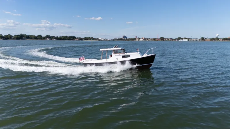 Slide: The Image of A 1959 Dyer 29 Trunk Cabin boat cruising on calm waters with a flag at the stern. - 36