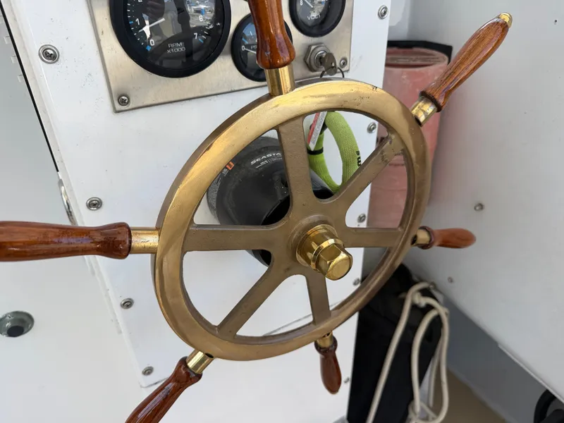 Slide: The Image of A classic brass steering wheel with wooden handles, surrounded by gauges and ropes. - 15