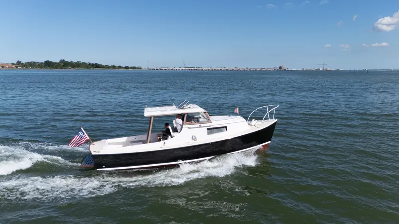 Slide: The Image of A 1959 Dyer 29 Trunk Cabin boat cruising on calm waters with an American flag. - 33