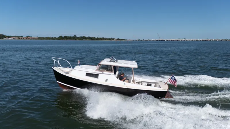 Slide: The Image of 1959 Dyer 29 Trunk Cabin on the water, featuring classic design and an American flag. - 41